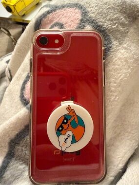 Red iPhone with Clear Case and Decorative Pop Socket